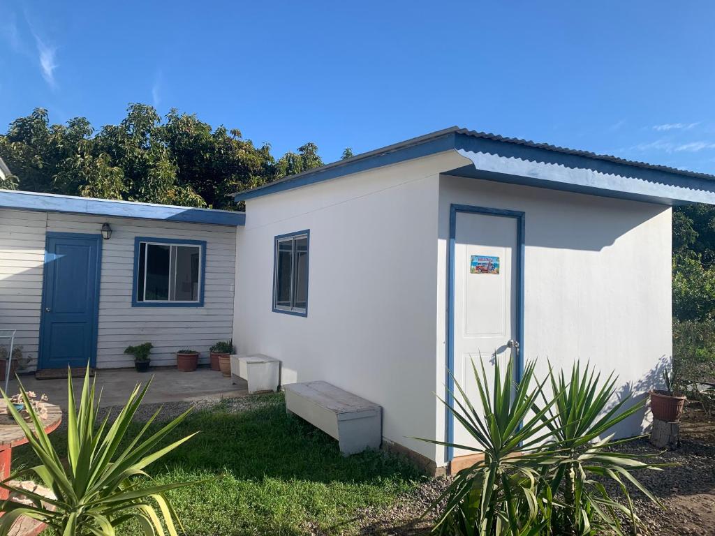 a small white house with a blue door at SOL DE LA PALMA in Quillota