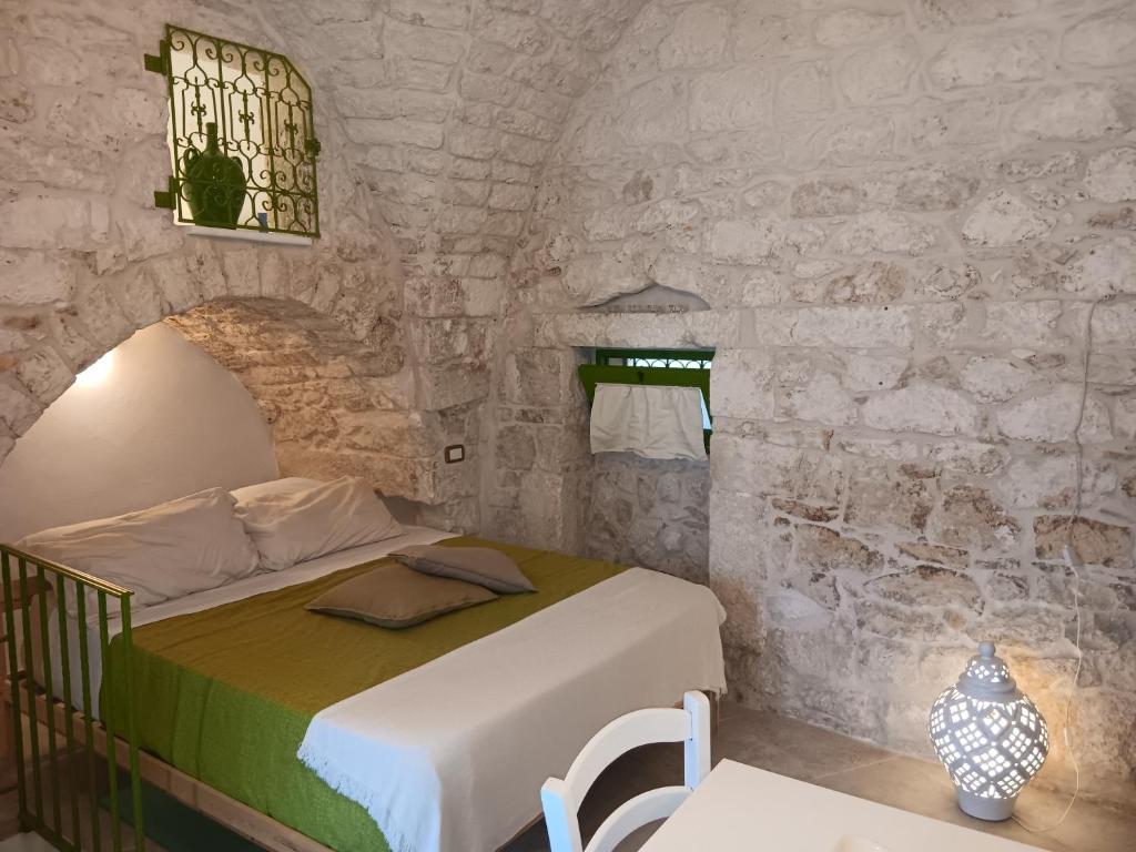 una camera da letto con un letto in un muro di pietra di Il Piccolo Frantoio - Locazione Turistica a Ostuni