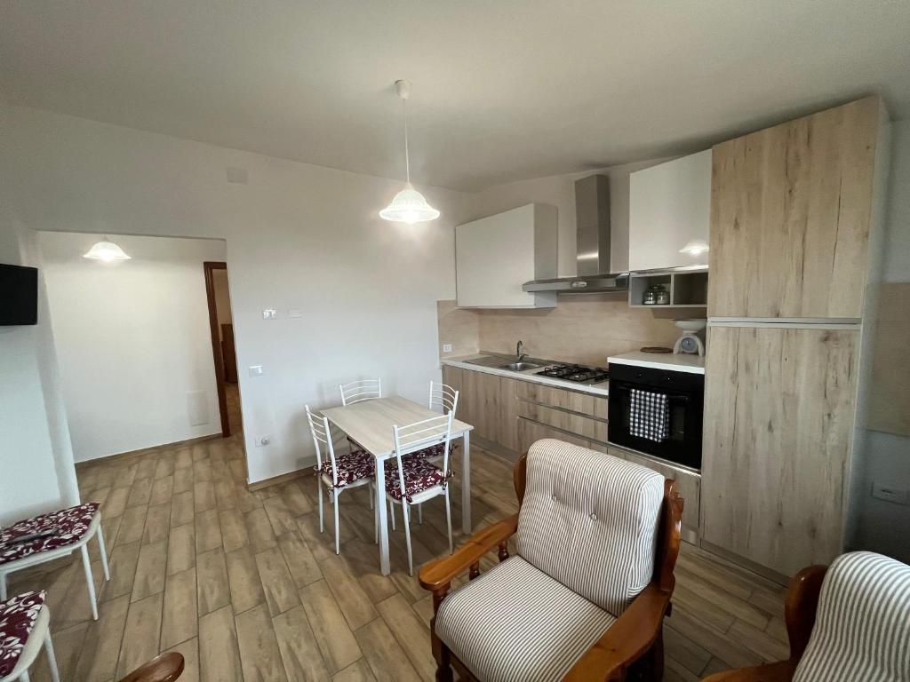 een keuken met een tafel en stoelen in een kamer bij Enjoy The Silence Flat in Orosei