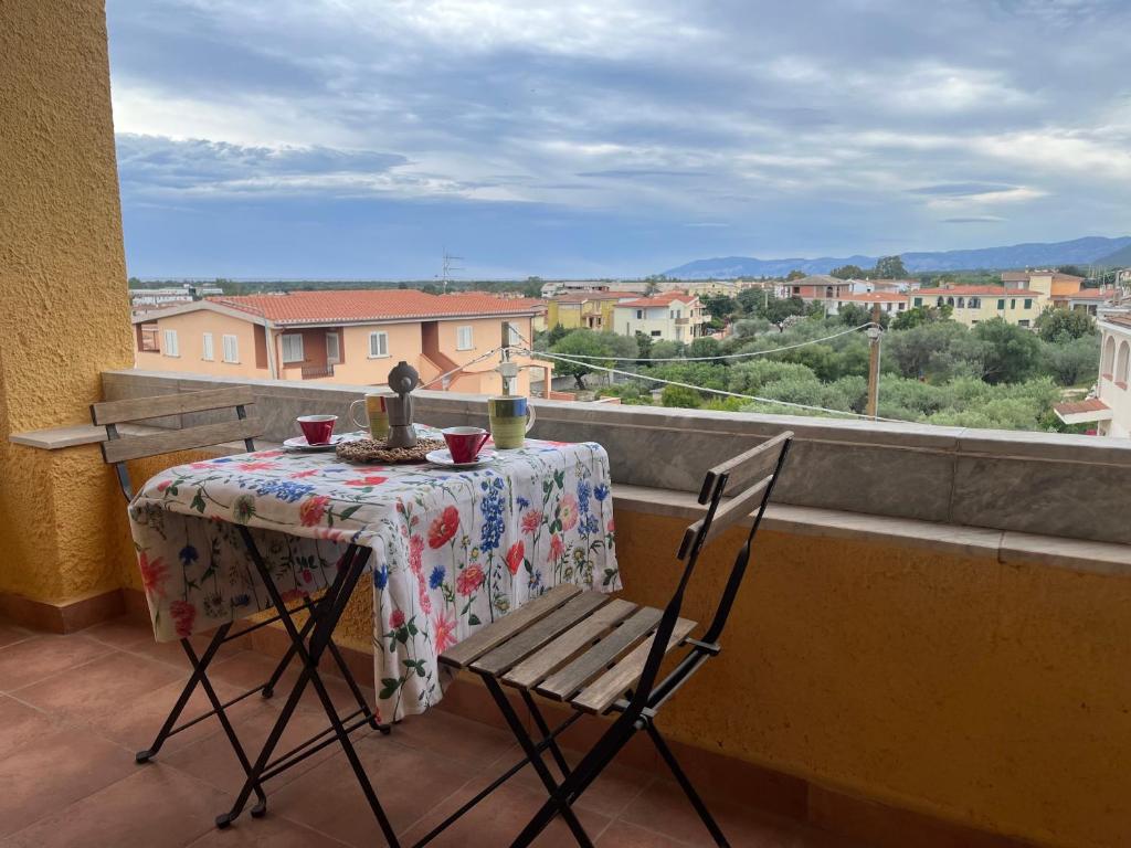 een tafel en stoelen op een balkon met uitzicht bij Cozy And Cool Flat in Orosei