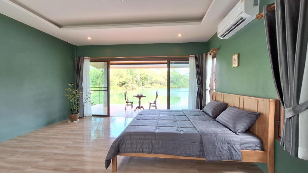 una camera da letto con un letto con una parete verde di Mama Home Misty Lakeside a Pong