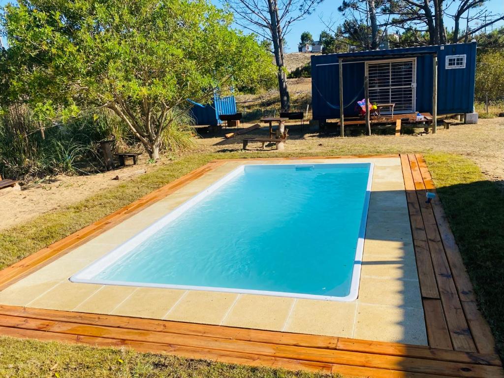 a small blue swimming pool in a yard at La Fresa glamping in Punta Del Diablo