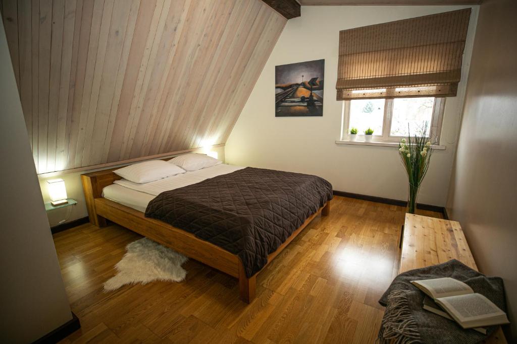 a bedroom with a bed and a window at Rest ART in Anykščiai