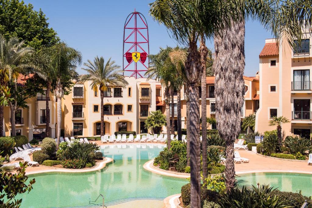 Una vista de un resort con piscina y palmeras. en PortAventura Hotel PortAventura - Includes unlimited access to PortAventura Park & 1 access to Ferrari Land, en Salou