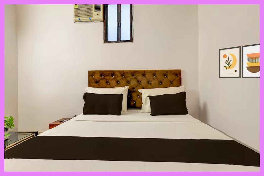 ein Schlafzimmer mit einem großen Bett mit schwarzem Kopfteil in der Unterkunft Hotel Renvlux Premium Stay in Puri