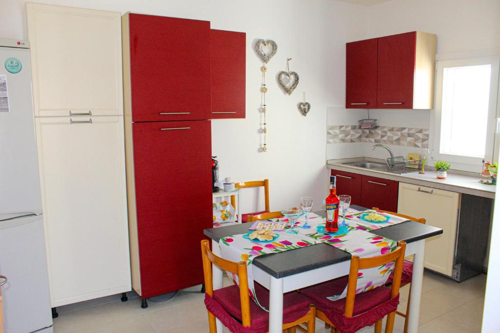 een keuken met een tafel en een rode koelkast bij A Casuzza di Pina e Raffaele in Villaggio Azzurro