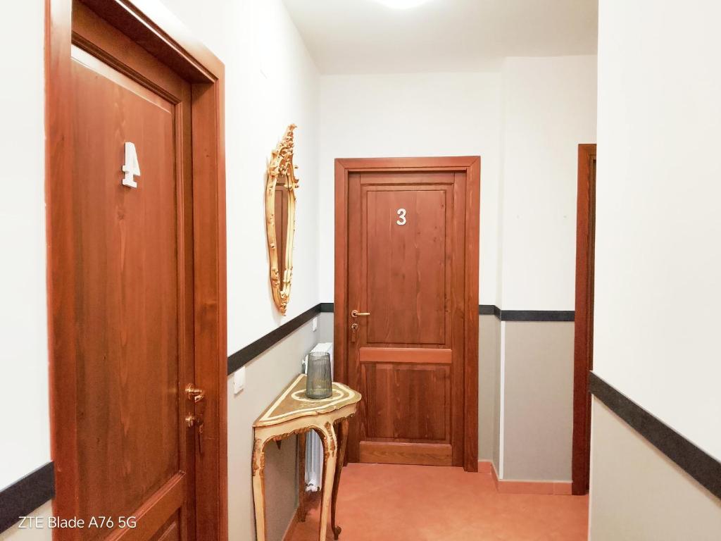 a hallway with a wooden door and a small table at La Villa Di Zio Pino in Camerino