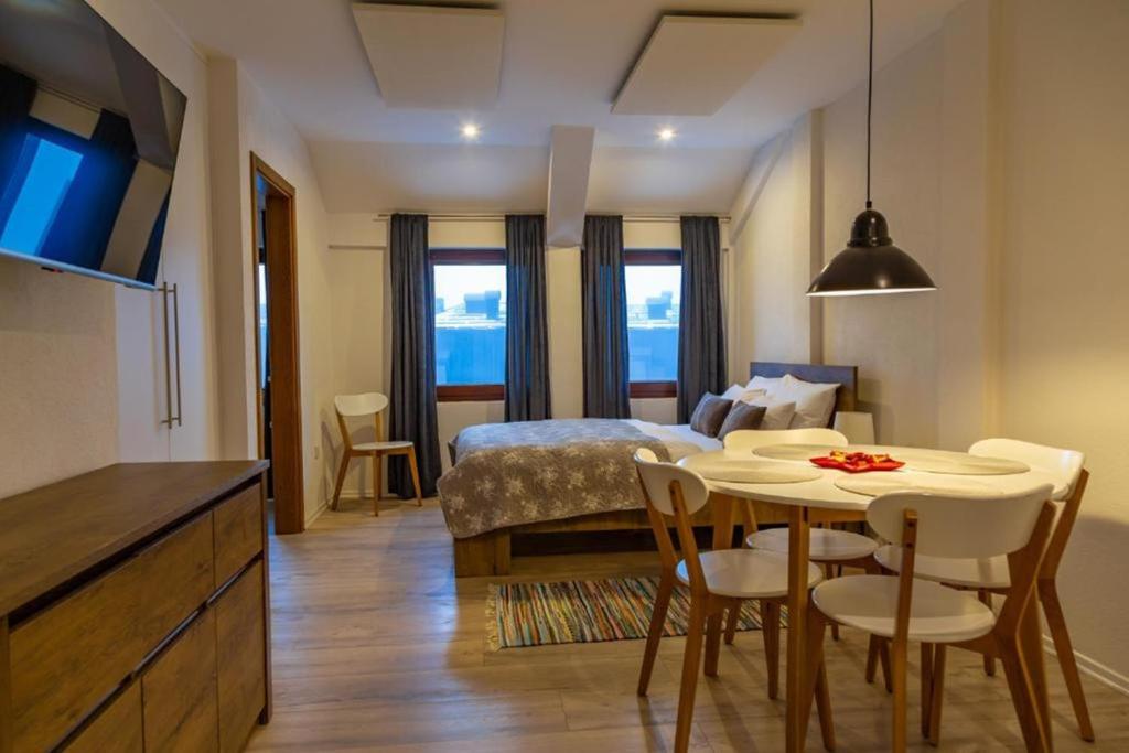 ein Zimmer mit einem Bett, einem Tisch und Stühlen in der Unterkunft Apartments Mont Jahorina in Jahorina