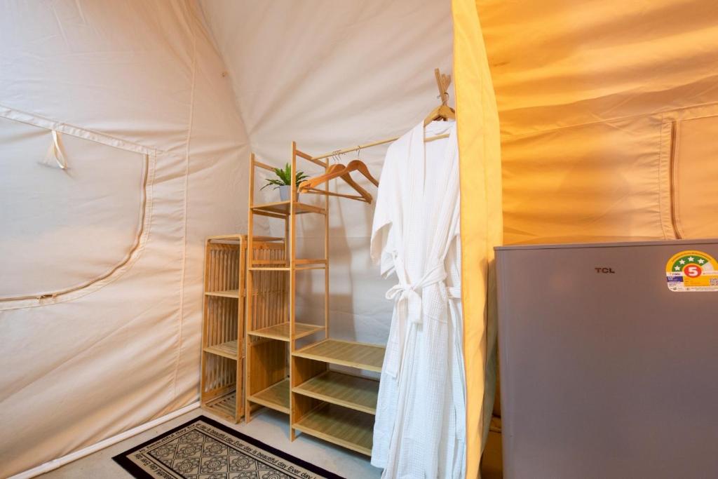 een kamer met een tent met een plank en een koelkast bij Camping&Cafe Khao Phratamnak in Pattaya South