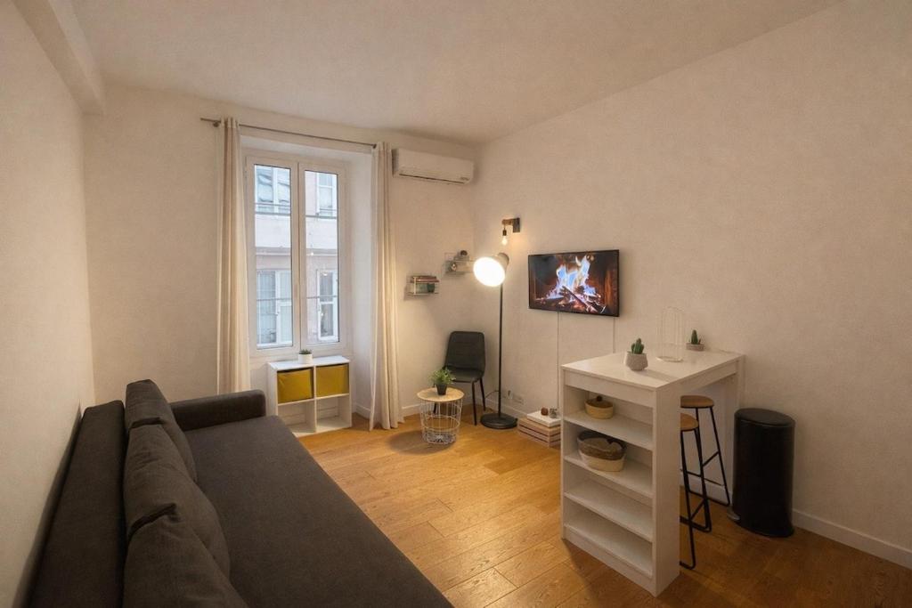 ein Wohnzimmer mit Sofa und Tisch in der Unterkunft Studio Moderne, Le Carré Dor, À 3min Plage, NICE CENTRE in Nizza