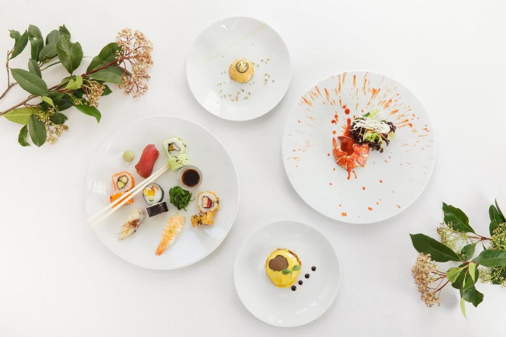 four white plates of food on a white table at InterContinental Madrid by IHG in Madrid