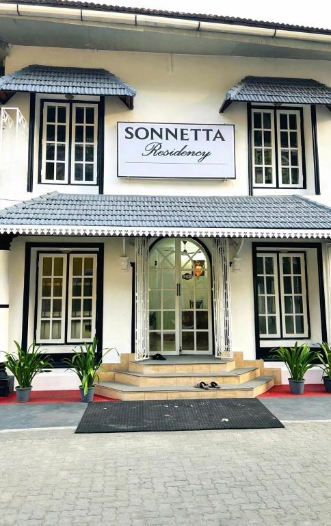 a store with a sign on the front of a building at Sonnetta Residency in Cochin