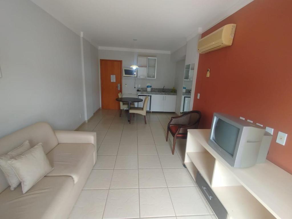 ein Wohnzimmer mit Sofa und Fernseher in der Unterkunft Apart Flat Aguas da Serra in Rio Quente