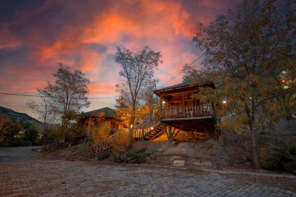 a house with a deck with a sunset in the background at OBA KÜTÜK EVLERi in Seben