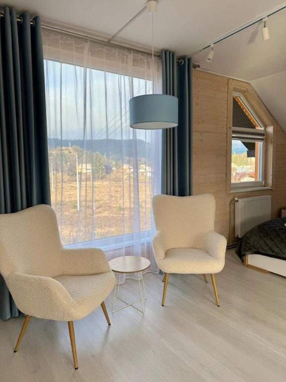 a bedroom with two chairs and a table and a bed at Іній in Vorokhta