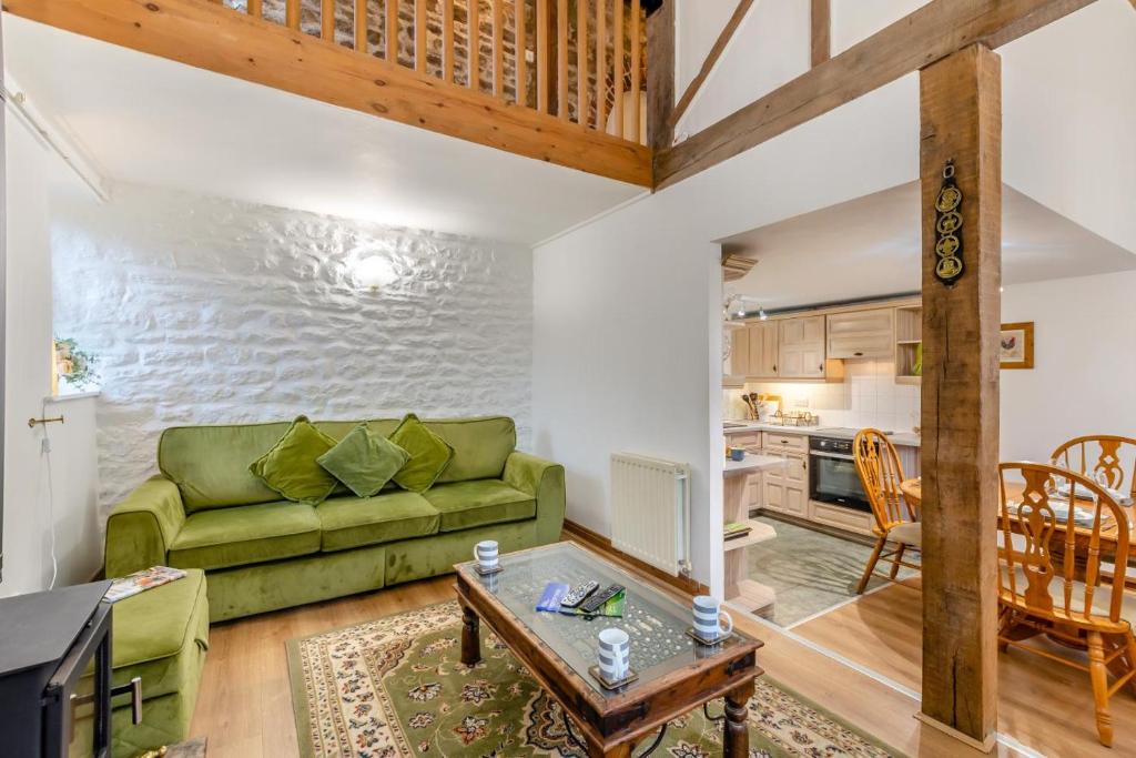 a living room with a green couch and a table at 3 Bed in Barden oc-s33752 in Sabden