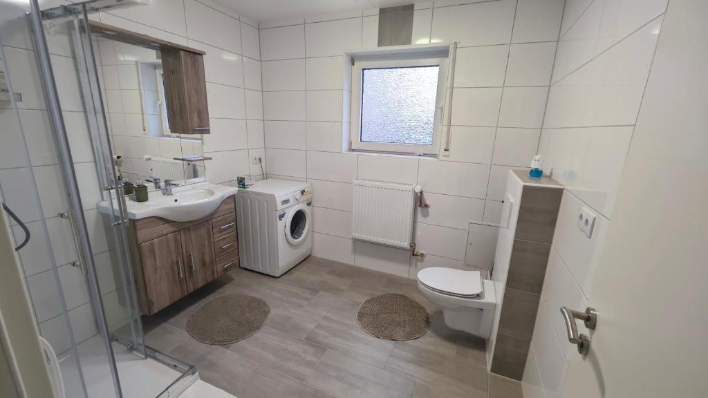 ein Badezimmer mit Toilette, Waschbecken und Waschmaschine in der Unterkunft Urlaub am Rhein Speyer Hockenheim Mannheim in Altlußheim