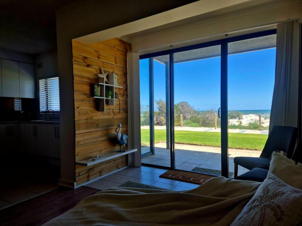 a bedroom with a large sliding glass door with a view at The Seaview at Semaphore Park in Port Adelaide
