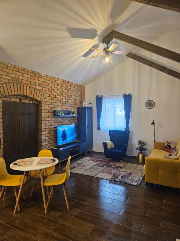 a living room with a table and yellow chairs at Marina Cottage in Enying