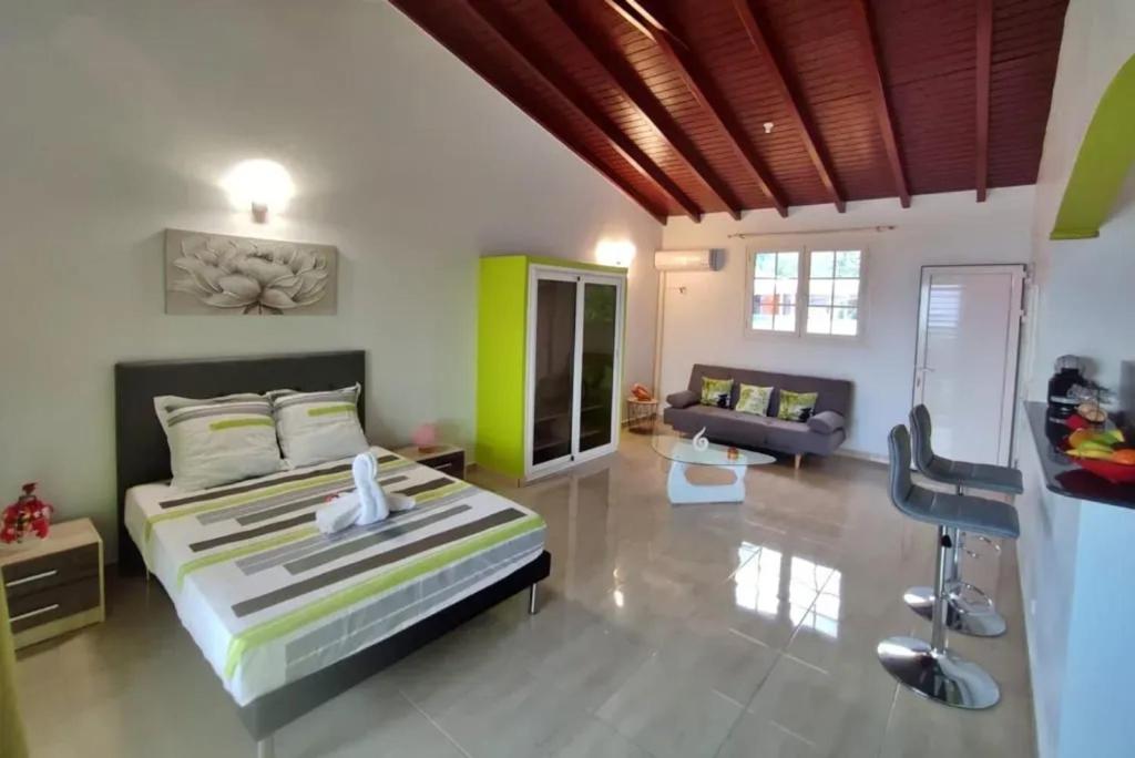 een slaapkamer met een bed en een woonkamer bij Studio moderne près de Capesterre-Belle-Eau avec piscine in Sainte-Marie des Bois