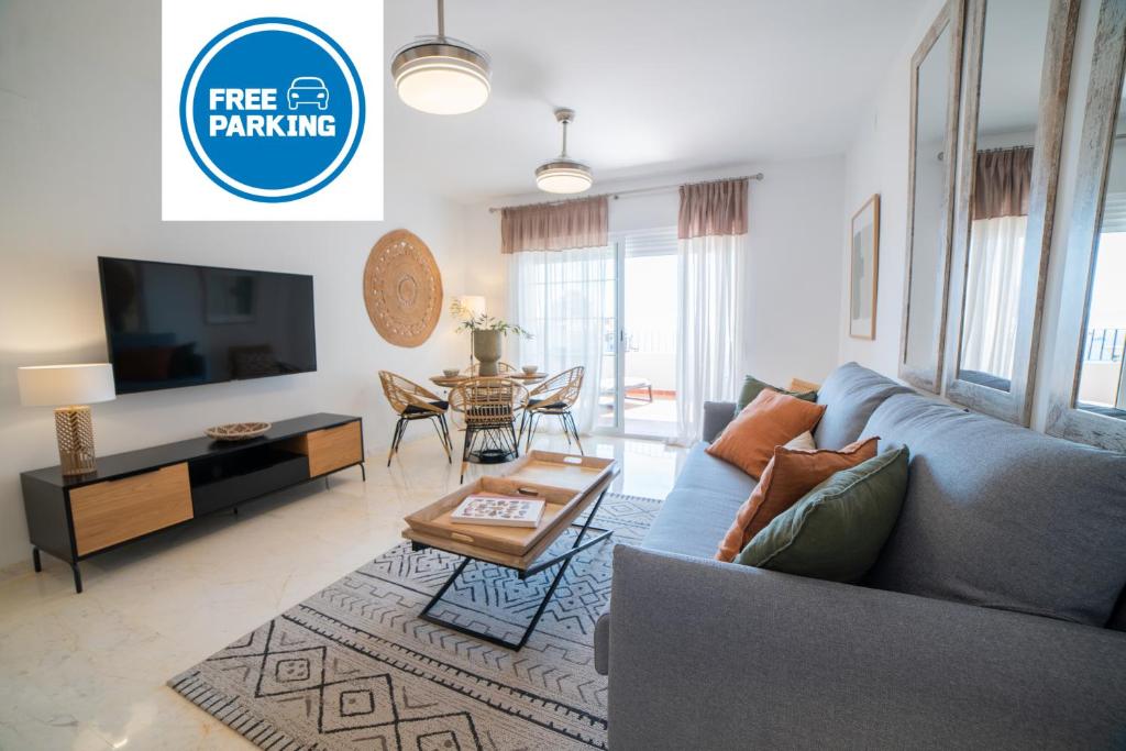 een woonkamer met een blauwe bank en een tafel bij Balcón de Marina del Este in La Herradura