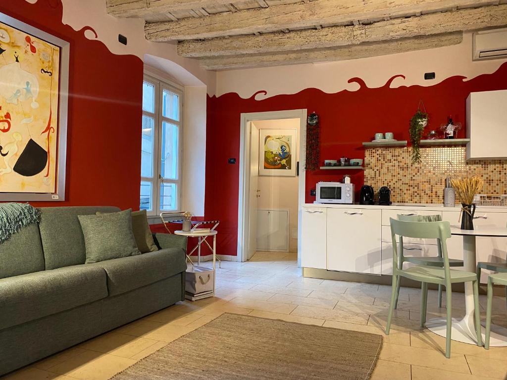 ein Wohnzimmer mit Sofa und eine Küche in der Unterkunft Loggiato Tassis Charme&Relax in Bergamo