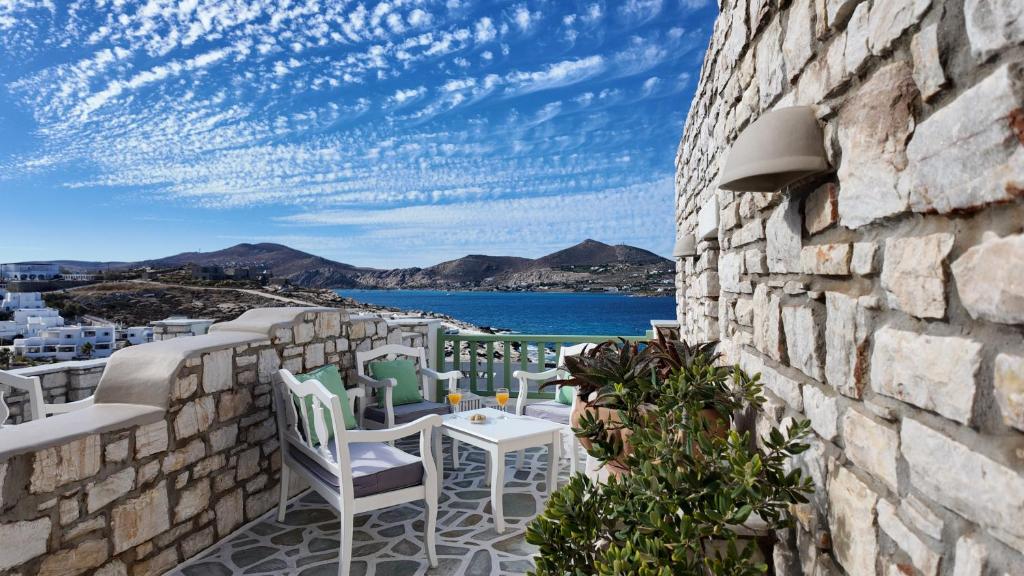 a patio with a table and chairs on a stone wall at Villa Isabella in Naousa