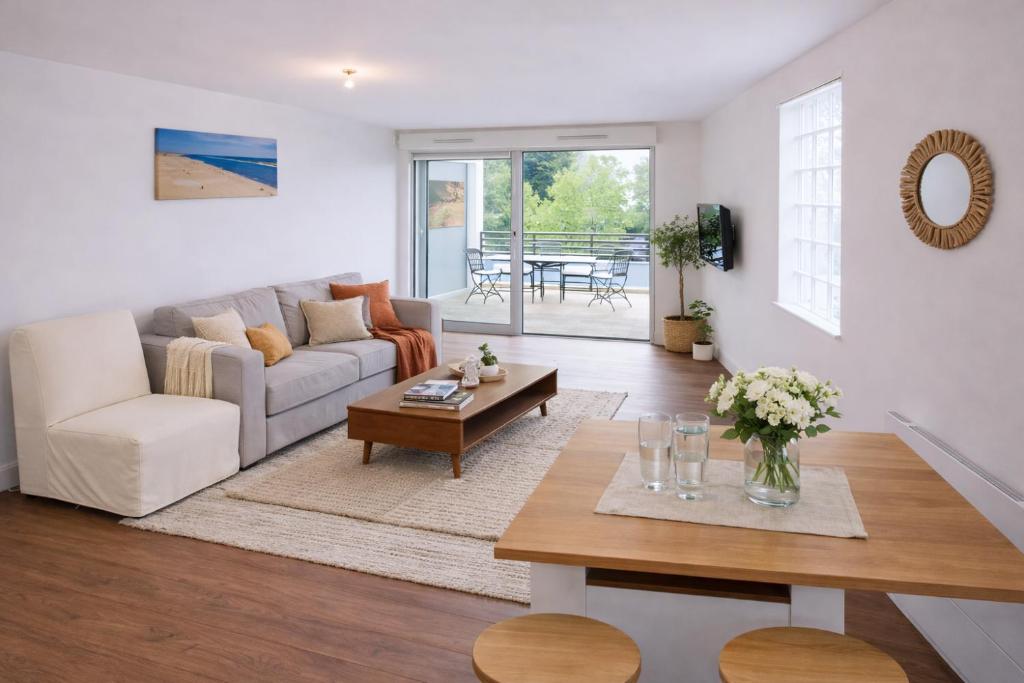 un soggiorno con un divano e un tavolo di Vaste studio 3 personnes avec balcon et parking a La Teste-de-Buch