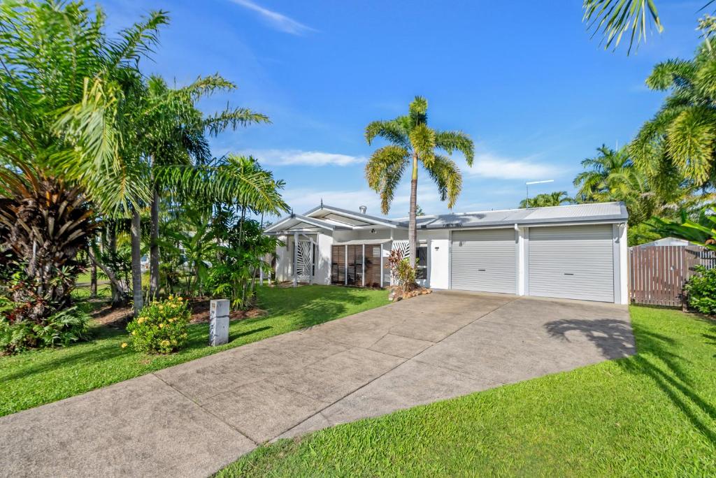 a house with a garage and palm trees at Eden House Kewarra Beach in Kewarra Beach