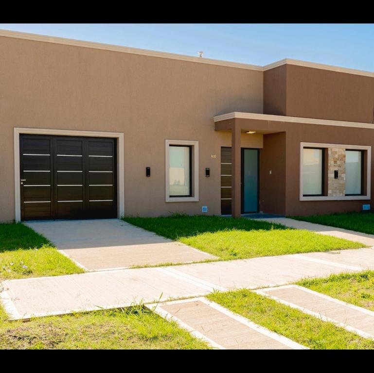 ein braunes Haus mit Garage und Einfahrt in der Unterkunft Casabella total confort y relax in Villa Elisa