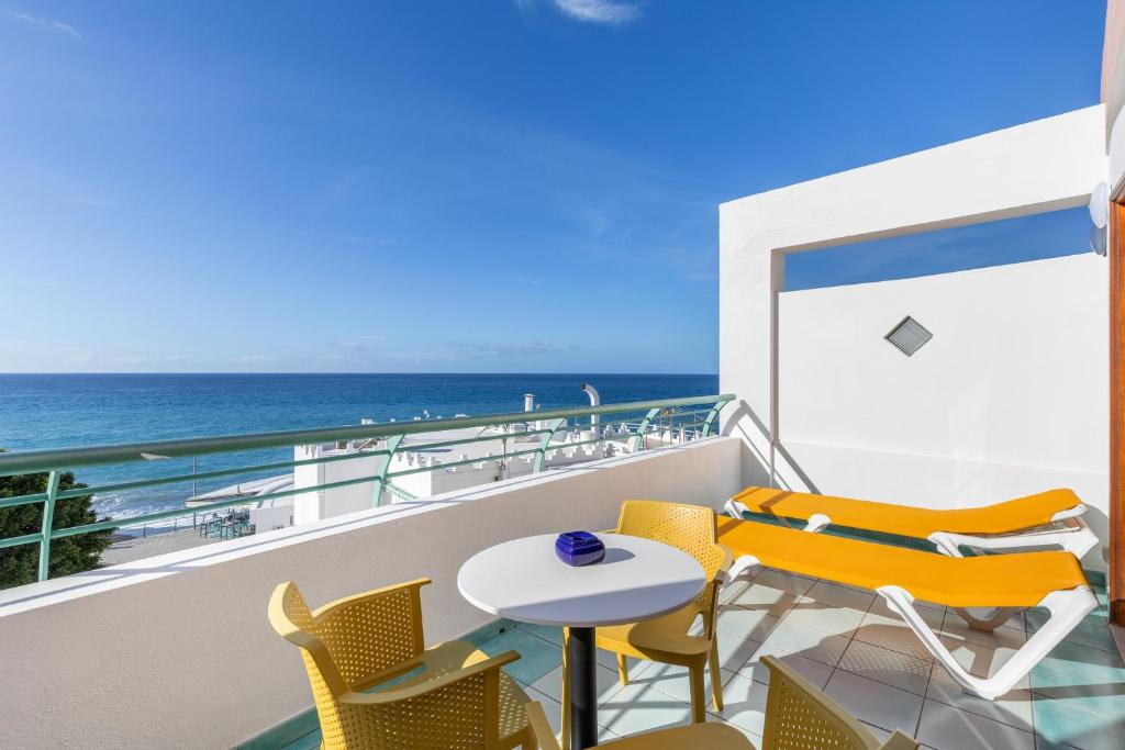 ein Balkon mit Tisch und Stühlen und dem Meer in der Unterkunft Playa Delphin 205 in Puerto Naos