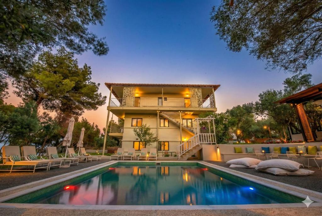 ein Haus mit einem Swimmingpool vor einem Gebäude in der Unterkunft Elies 33 Bio Retreat in Afytos