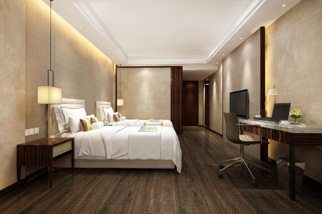 a bedroom with a bed and a desk and a computer at Hotel Vivanta Residency Delhi Airport in New Delhi