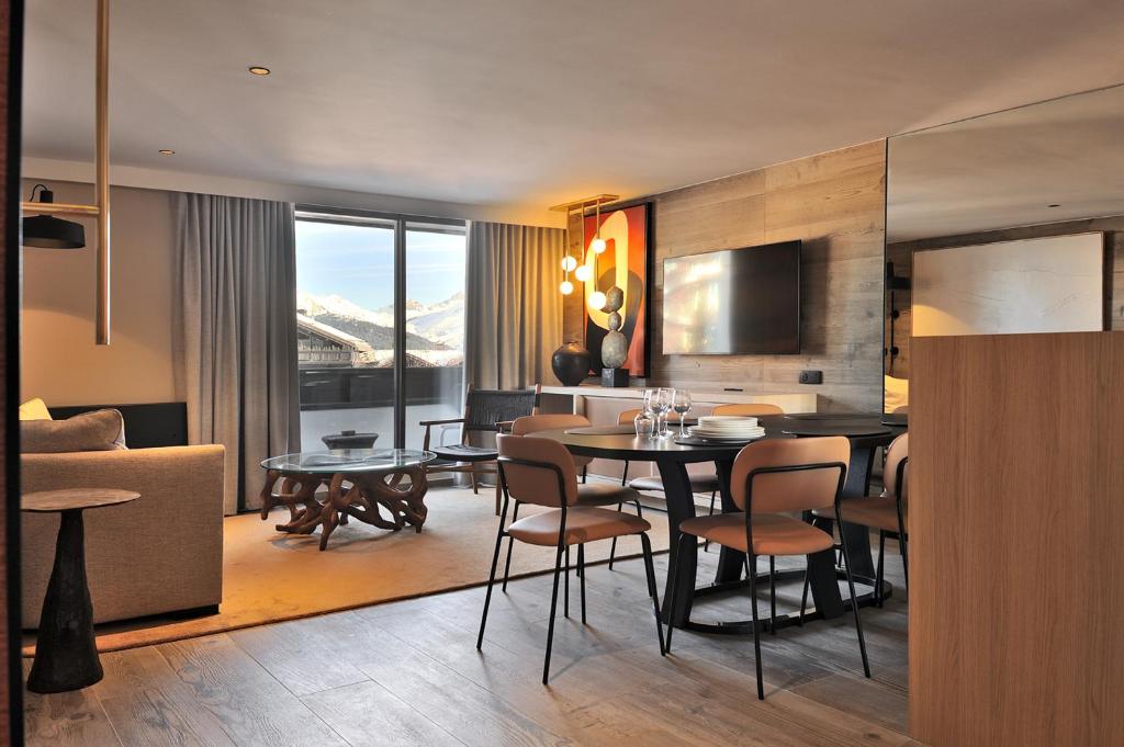 ein Esszimmer und ein Wohnzimmer mit Tisch und Stühlen in der Unterkunft La Résidence Belledonne in Courchevel