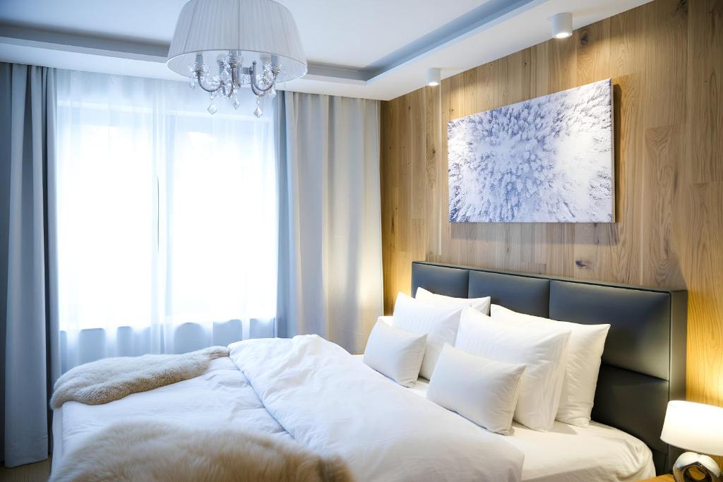 a bedroom with a large bed with white pillows at NĀVA PLACE Cozy home in Kaprun in Kaprun