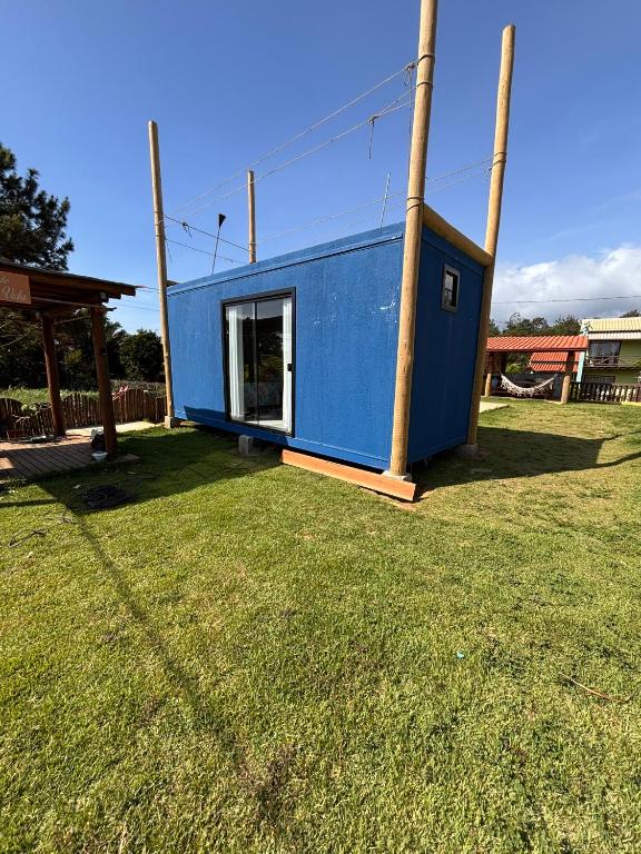 une maison bleue avec un poteau dans une cour dans l'établissement Container - Pura Vida, à Uruçuca