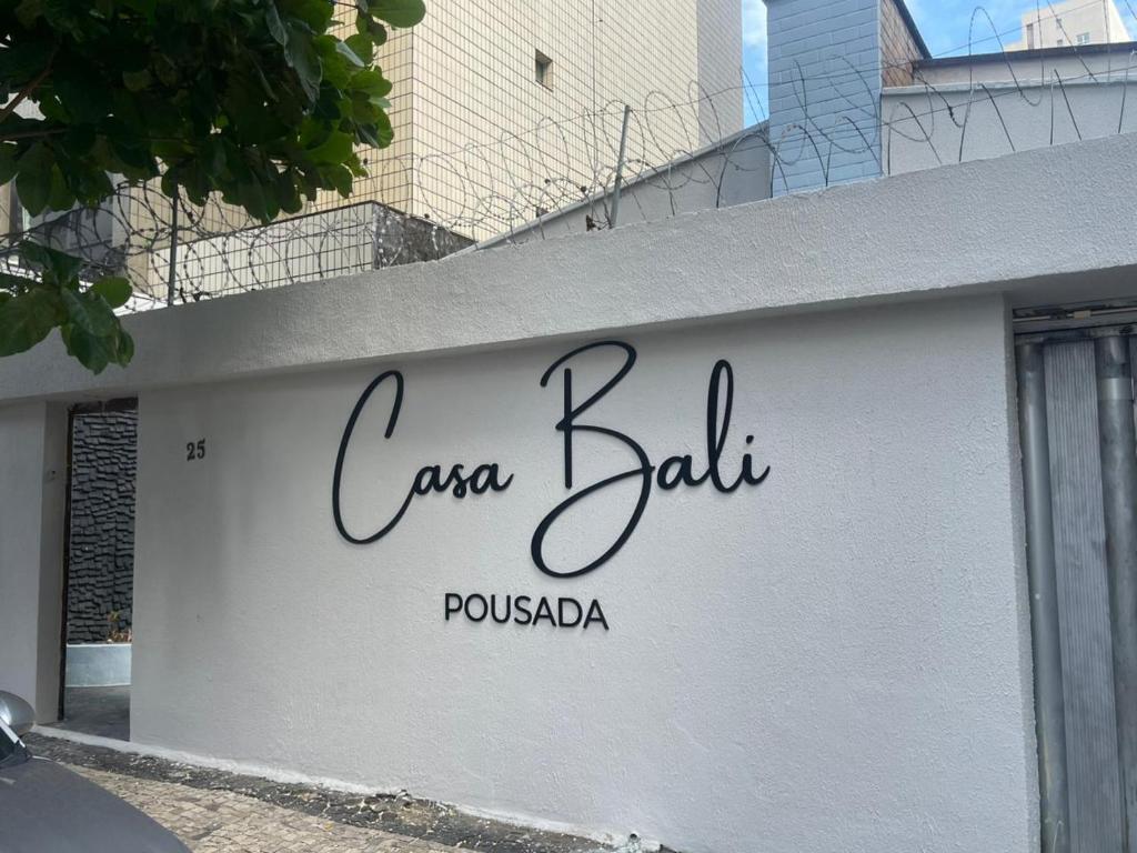 a white wall with the words caza bat on it at Pousada Casa Bali in Fortaleza