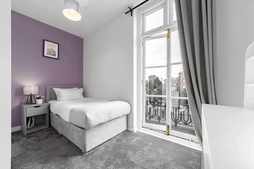 a bedroom with a bed and a large window at Harbour Hub Hotel in Southampton