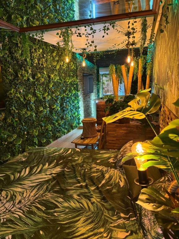 a living room with a green wall with plants at Jungle Room in Perpignan