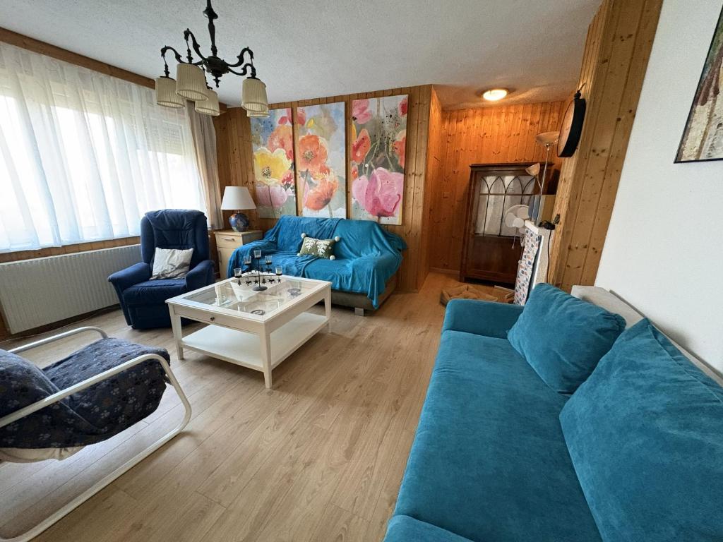 a living room with blue couches and a table at Ferienhaus Gansbach in Gansbach