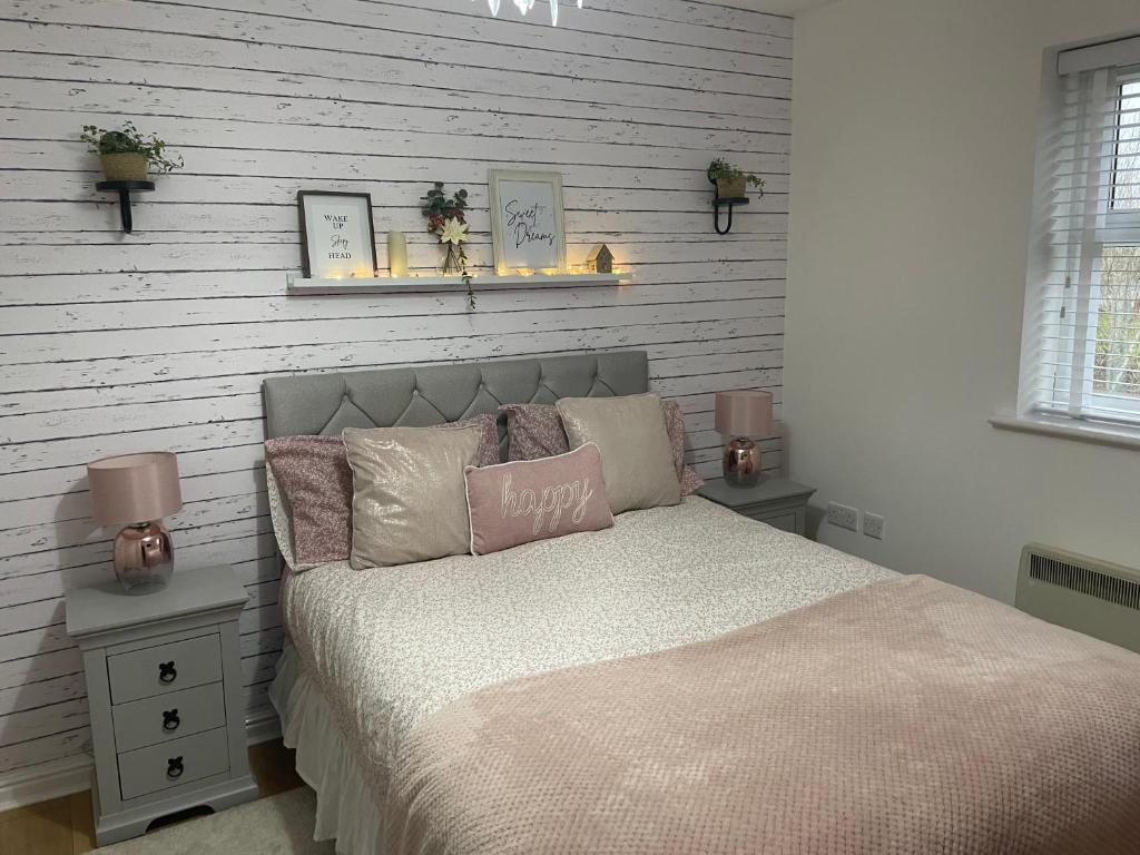 ein Schlafzimmer mit einem Bett mit zwei Lichtern an der Wand in der Unterkunft Double room with en-suite in Halton