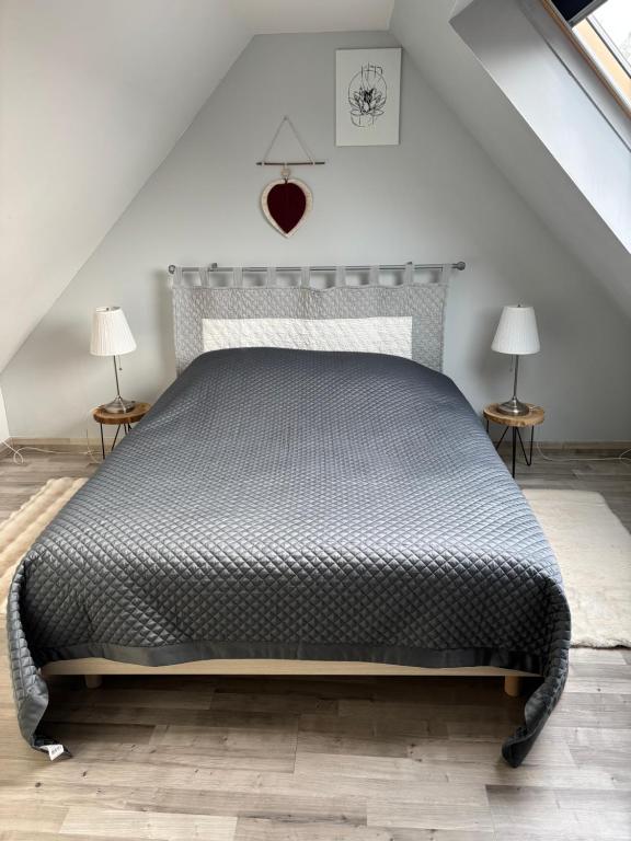 ein Schlafzimmer mit einem Bett und zwei Endtischen in der Unterkunft Au bonheur des hirondelles in Kirrwiller