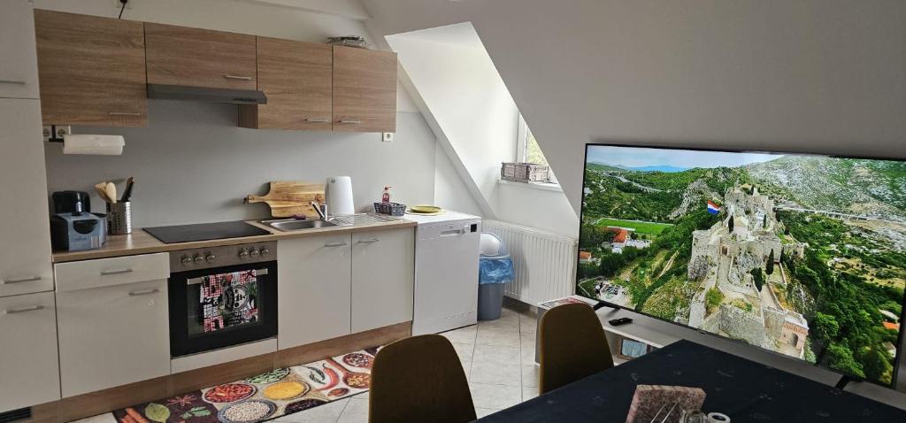 a kitchen with a flat screen tv in a kitchen at stilvolles Apartment für 4 Personen in Ulmerfeld in Ulmerfeld
