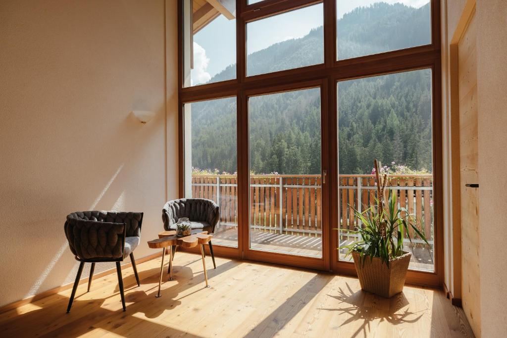 een kamer met twee stoelen en een groot raam bij New Opening Penthouse Zirm in Selva dei Molini