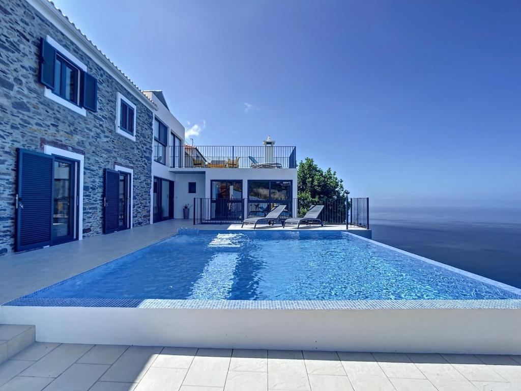 ein Swimmingpool vor einem Haus in der Unterkunft Villa Espigão With Pool in Fajã da Ovelha