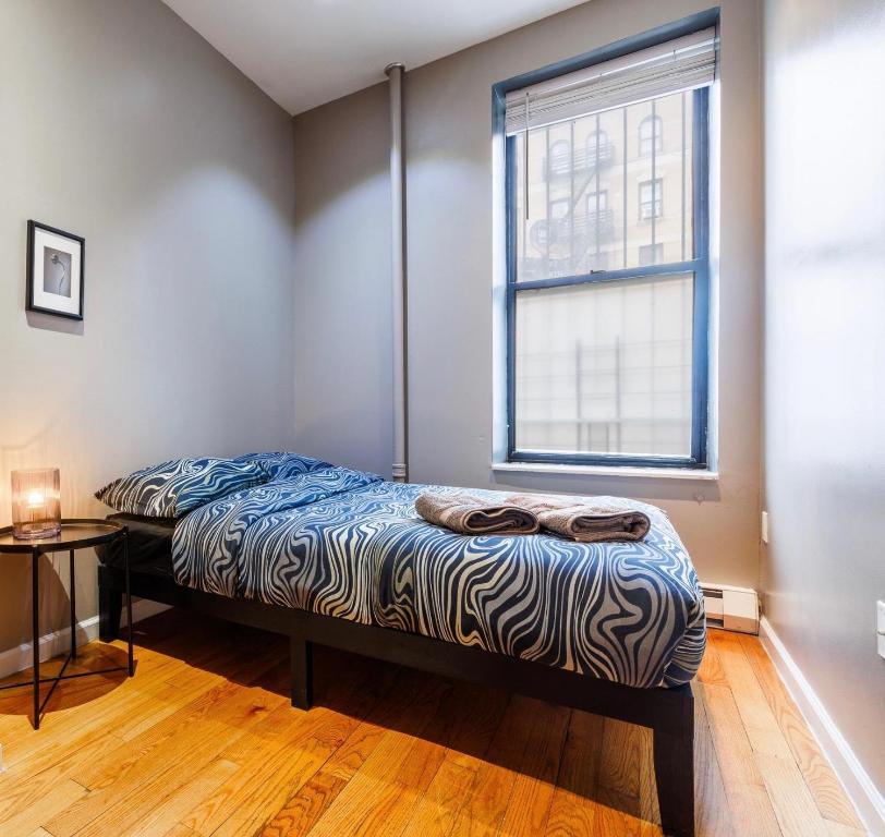 un letto in una stanza con una finestra di Budget Comfortable Apartments a New York