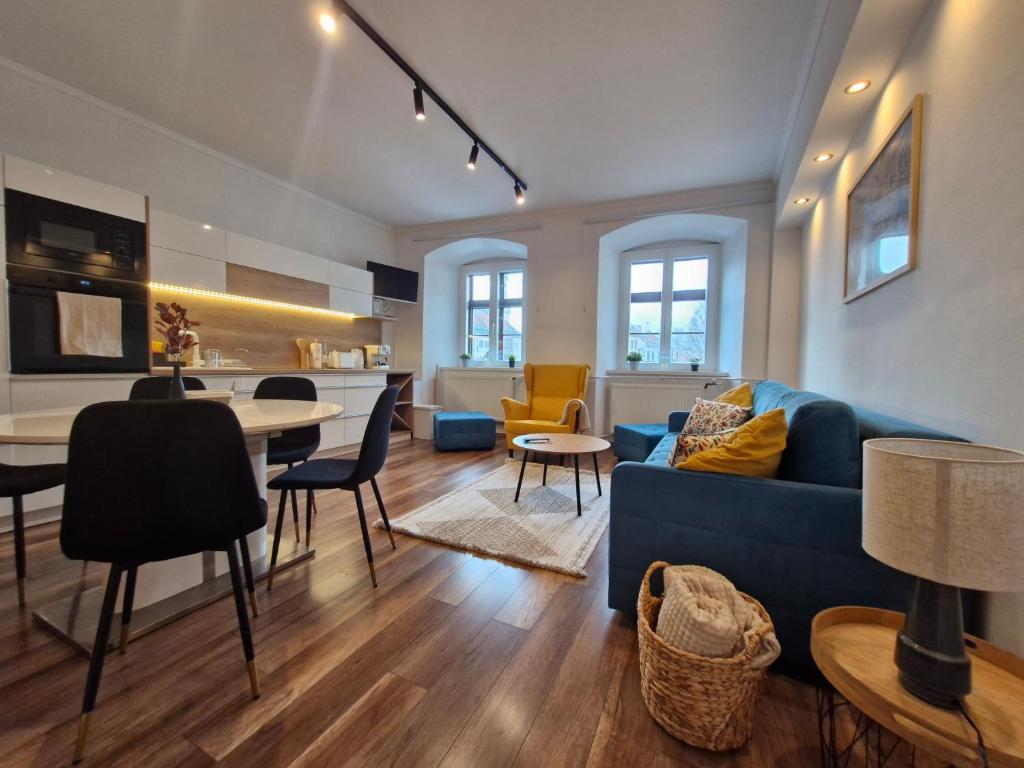 een woonkamer met een blauwe bank en een tafel bij Várker39 Apartman in Sopron