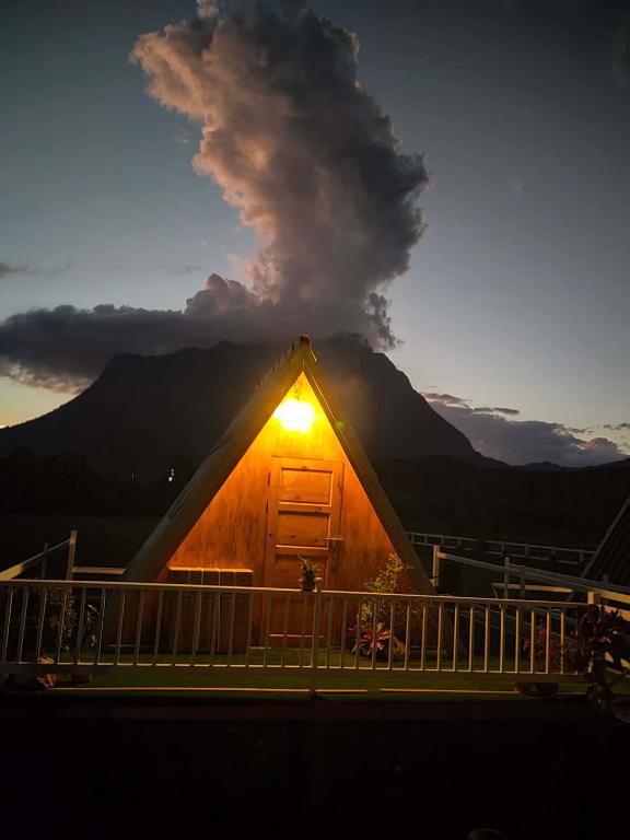a lit up cabin with a mountain in the background at Western View Chiangdao Camping in Chiang Dao