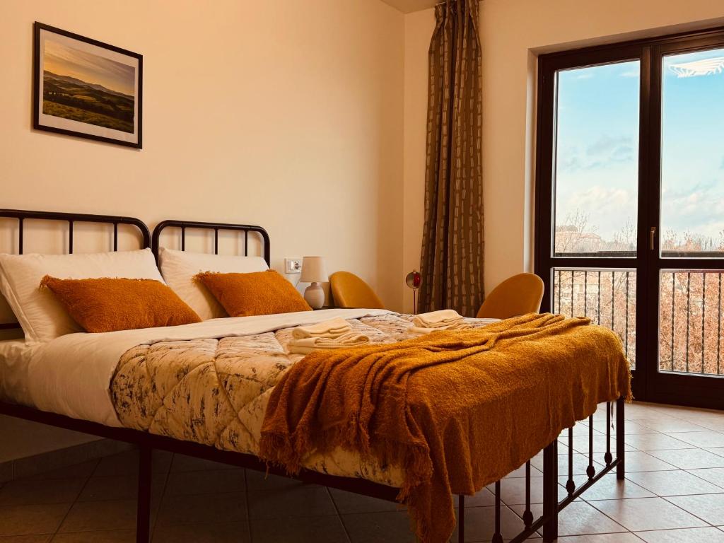 ein Schlafzimmer mit einem Bett und einem großen Fenster in der Unterkunft Casa di Stella in Montepulciano