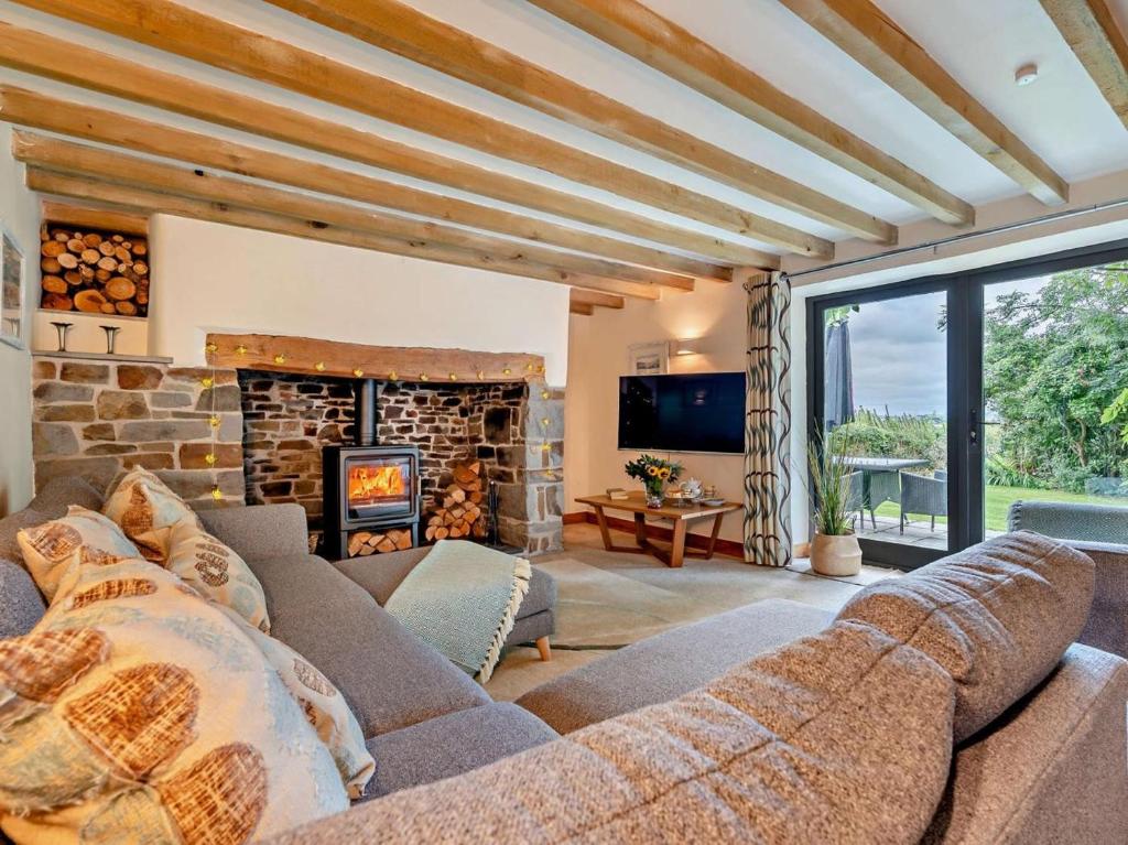 een woonkamer met een bank en een open haard bij 2 Bed in Bude oc-64088 in Marhamchurch